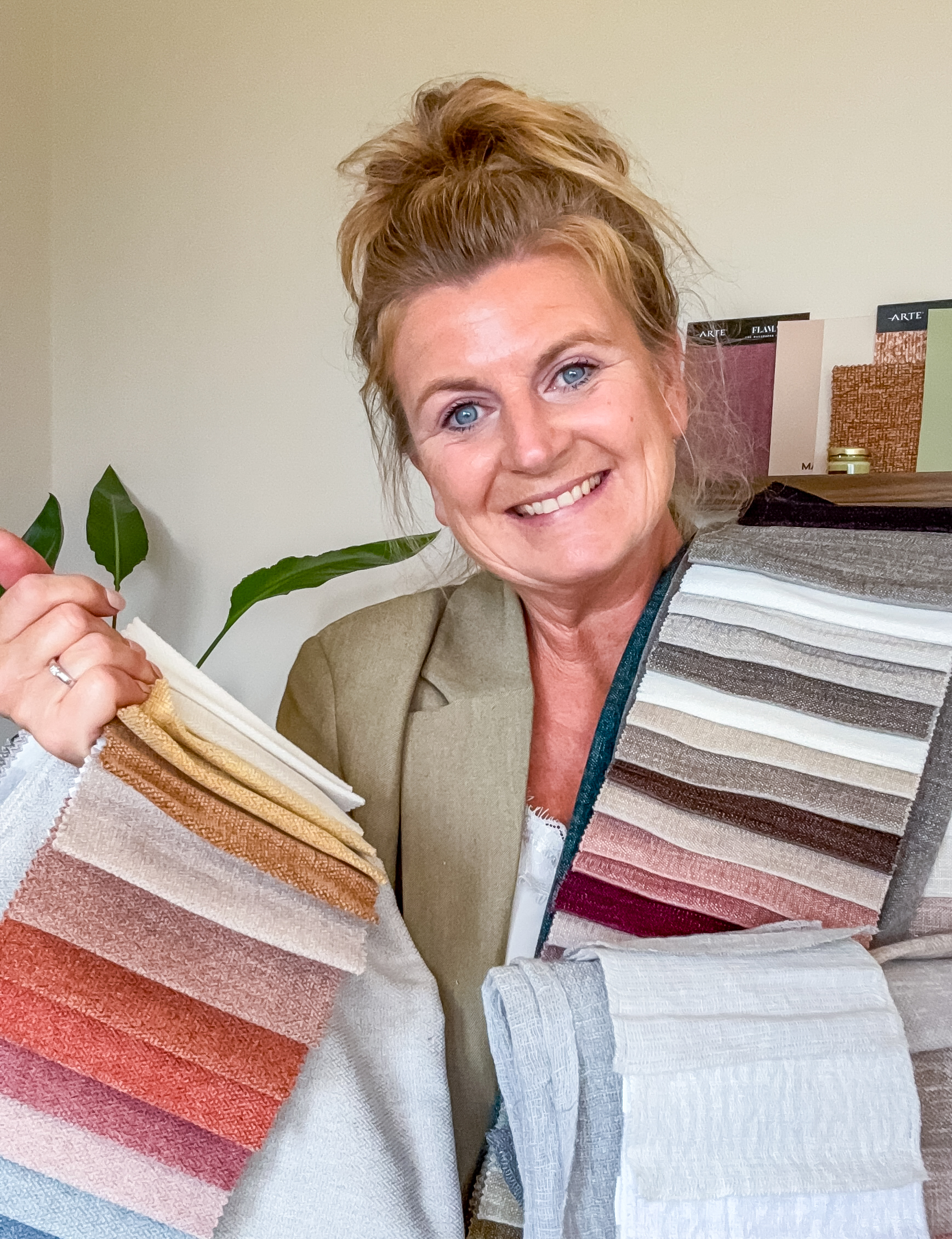 Interieurontwerper [Jouw Naam] geeft stylingadvies met kussens en plaids tijdens een Interieur Boost aan huis.